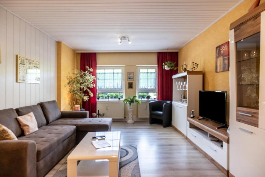 a living room with a couch and a tv at Günthers Wattstube in Schweiburg