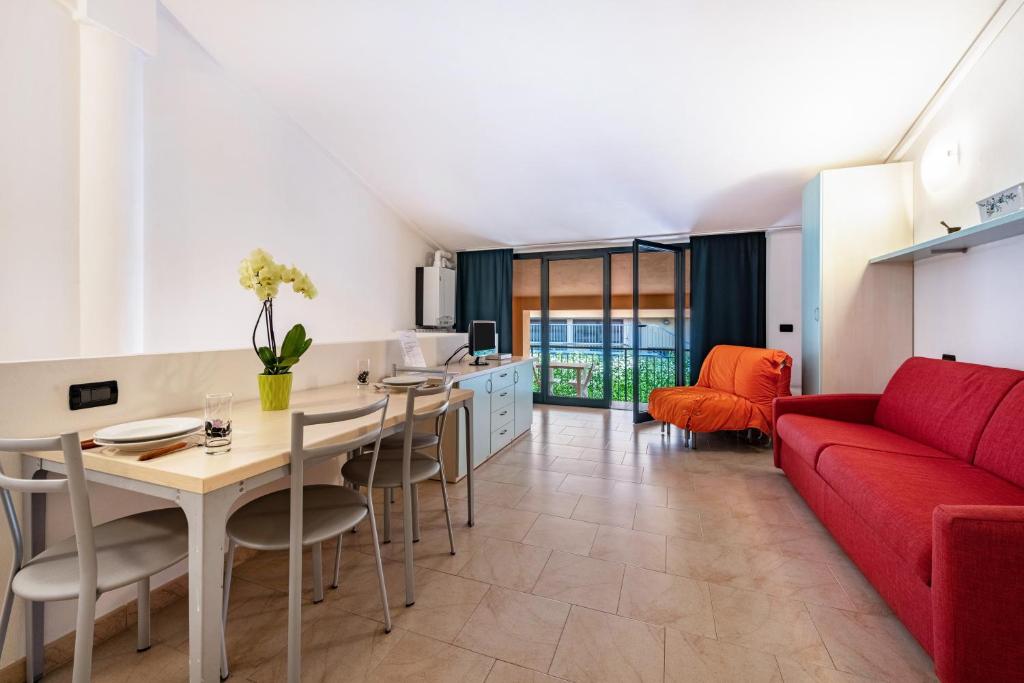 a living room with a red couch and a table at Cozy studio Le Vele Garda Lake in Toscolano Maderno