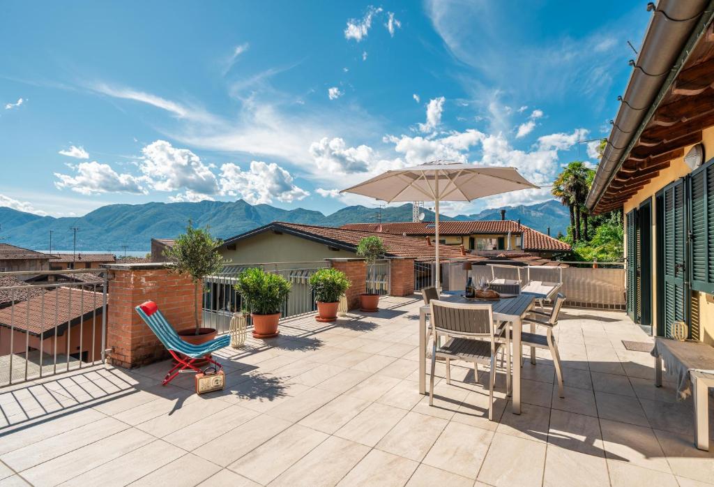 a patio with a table and chairs and an umbrella at Central Penthouse Luino in Luino