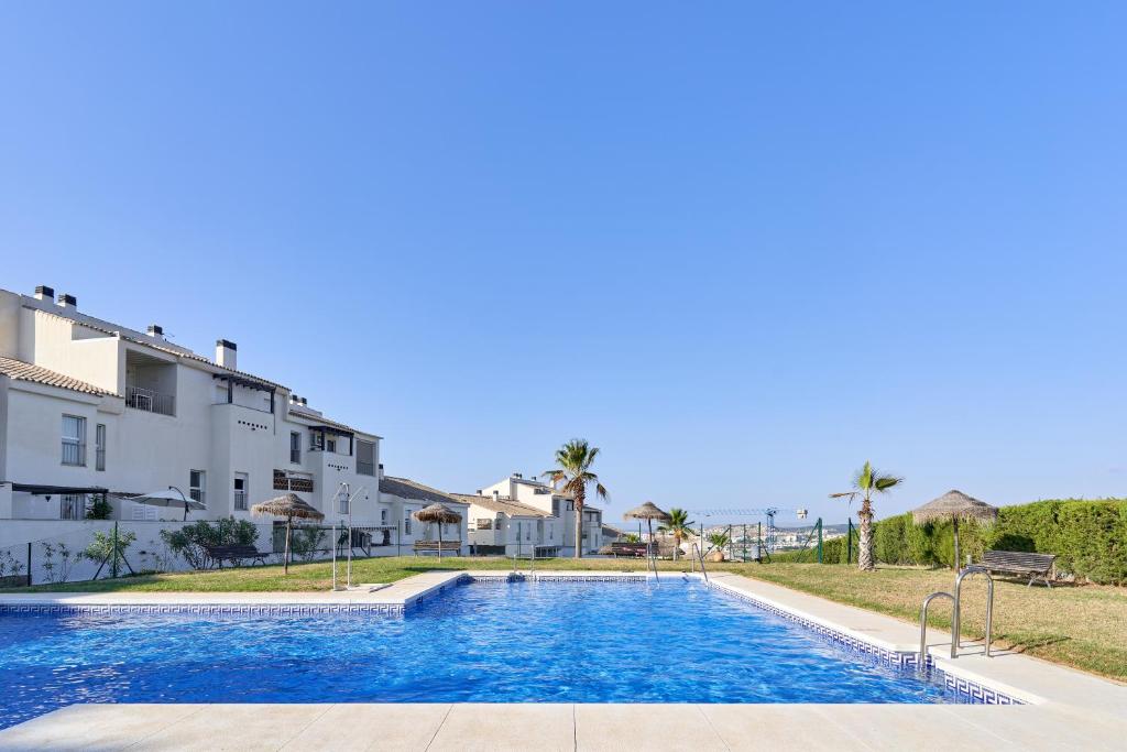 a swimming pool in front of a building at Apartamento Baviera Golf 002 in Vélez-Málaga