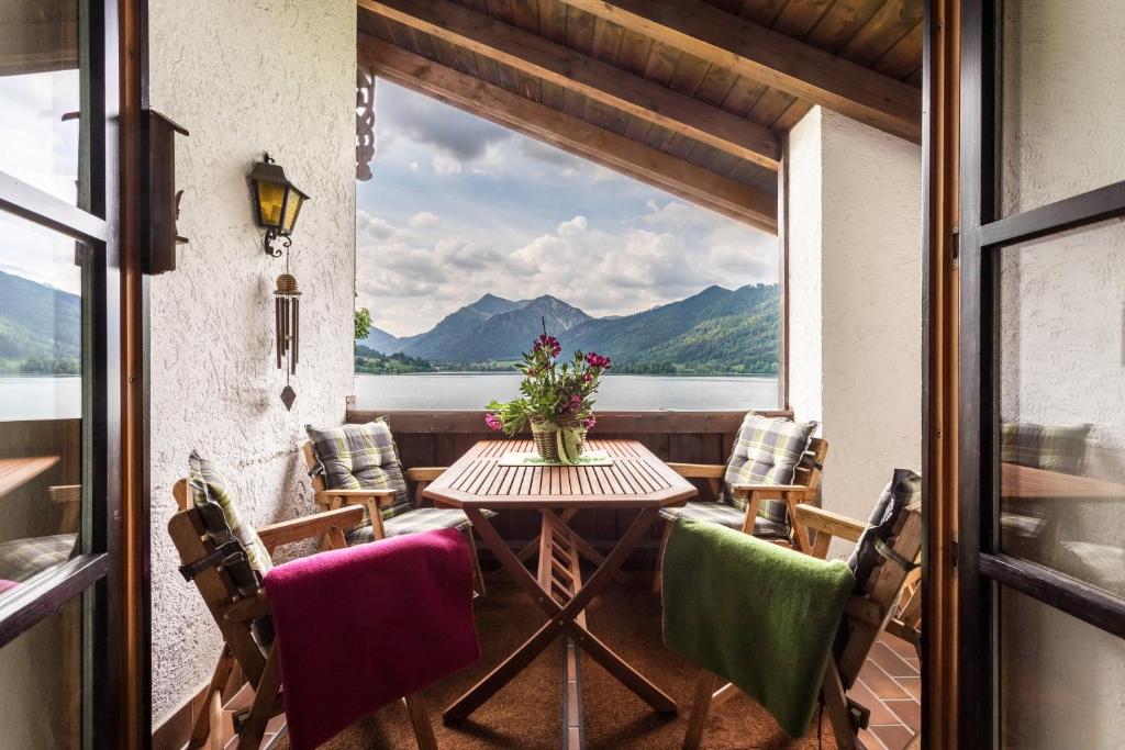 a table and chairs on a balcony with a view at Ferienwohnung Riepl in Schliersee