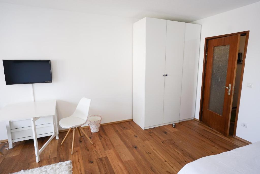 a bedroom with a bed and a desk and a tv at Zentral und Naturnah in Penzberg
