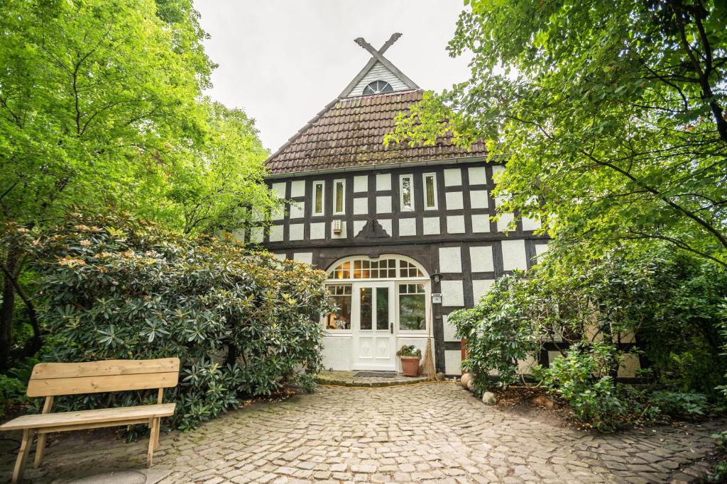a black and white house with a bench in front of it at Ferienwohnung Lieblingsplatz in Bremen