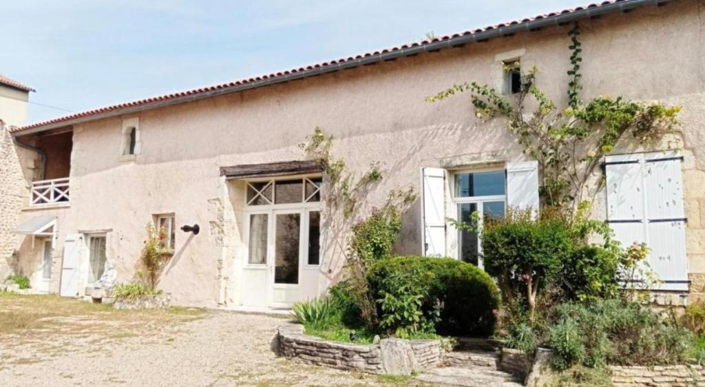 a house with a tree in front of it at Gite Terre Happy Ribérac in Ribérac