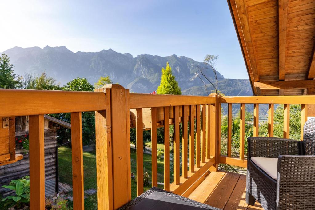 a wooden deck with chairs and mountains in the background at Maso Gigi in Castel Ivano