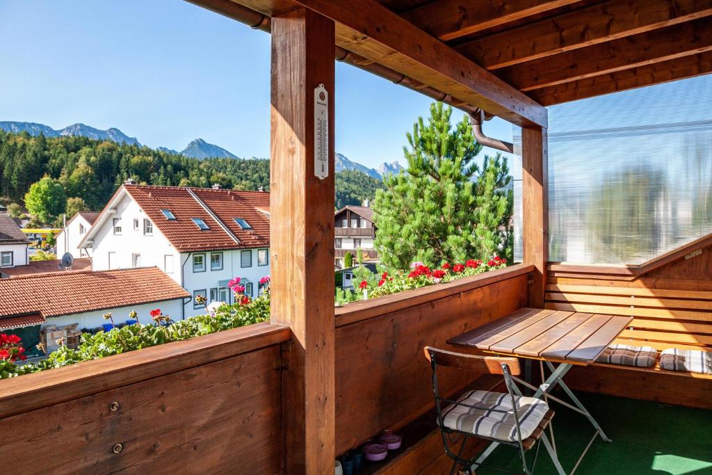 a wooden balcony with a wooden table and a window at Paulas Ferienwohnung Koenigscard in Füssen
