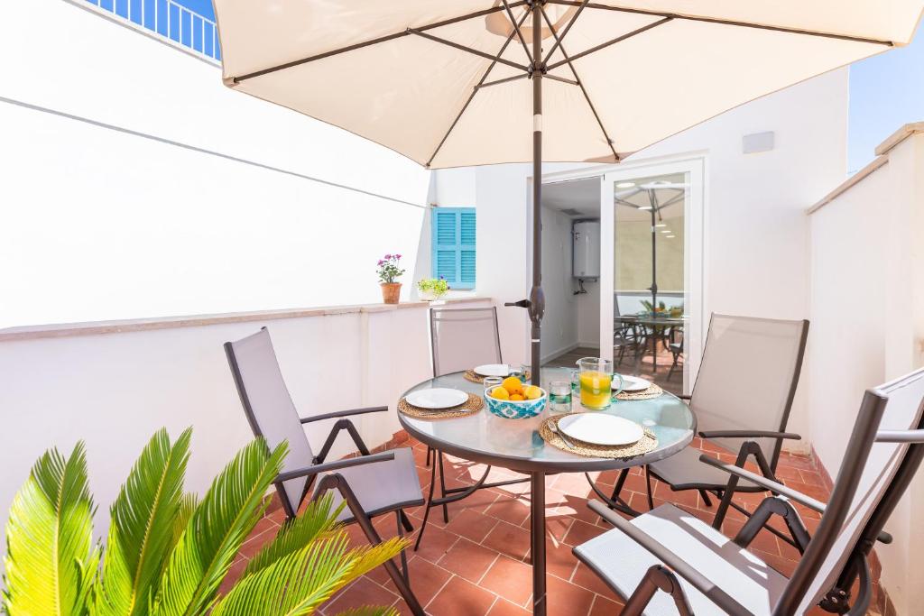a patio with a table and chairs and an umbrella at Albercutx Pollentia 3 in Pollença