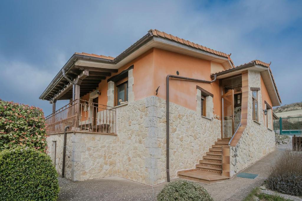 a house with a stone wall and stairs at La Cardeñuela in Burgos
