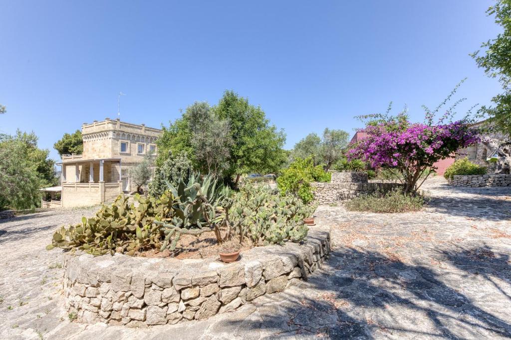 a garden with plants in a stone wall at Le Colonie - Pescoluse in Presicce