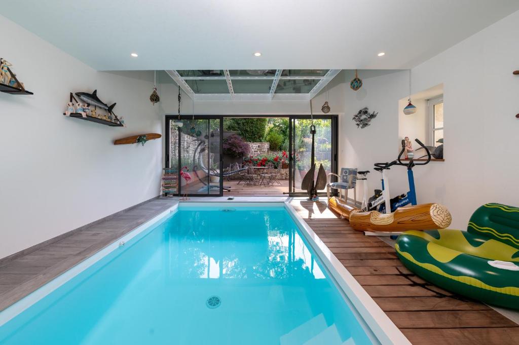 a swimming pool in a house with a gym at Ty Al Louarn - Piscine - Spa in Brech