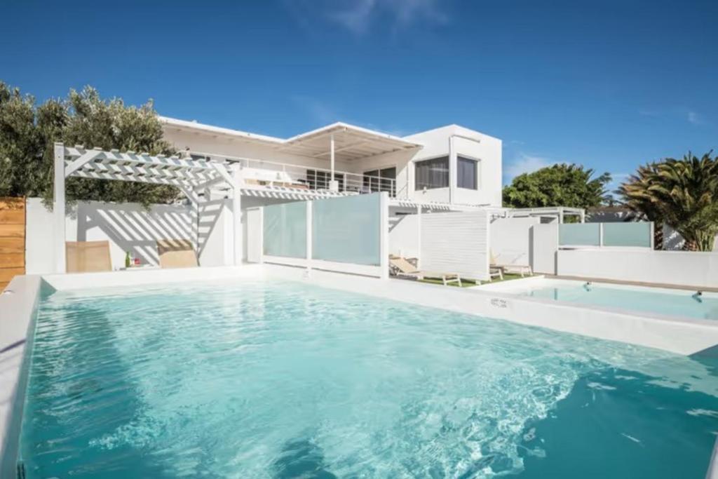a swimming pool in front of a house at Amanecer 4 in Mácher