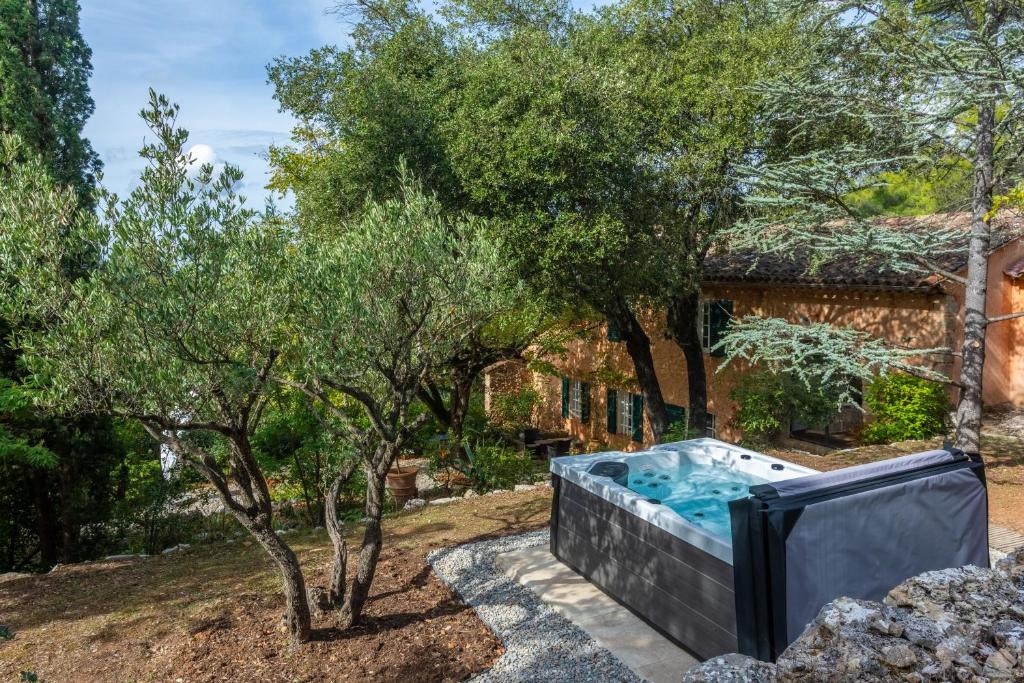 a hot tub in a garden next to a house at Maison de charme avec jacuzzi in Lorgues