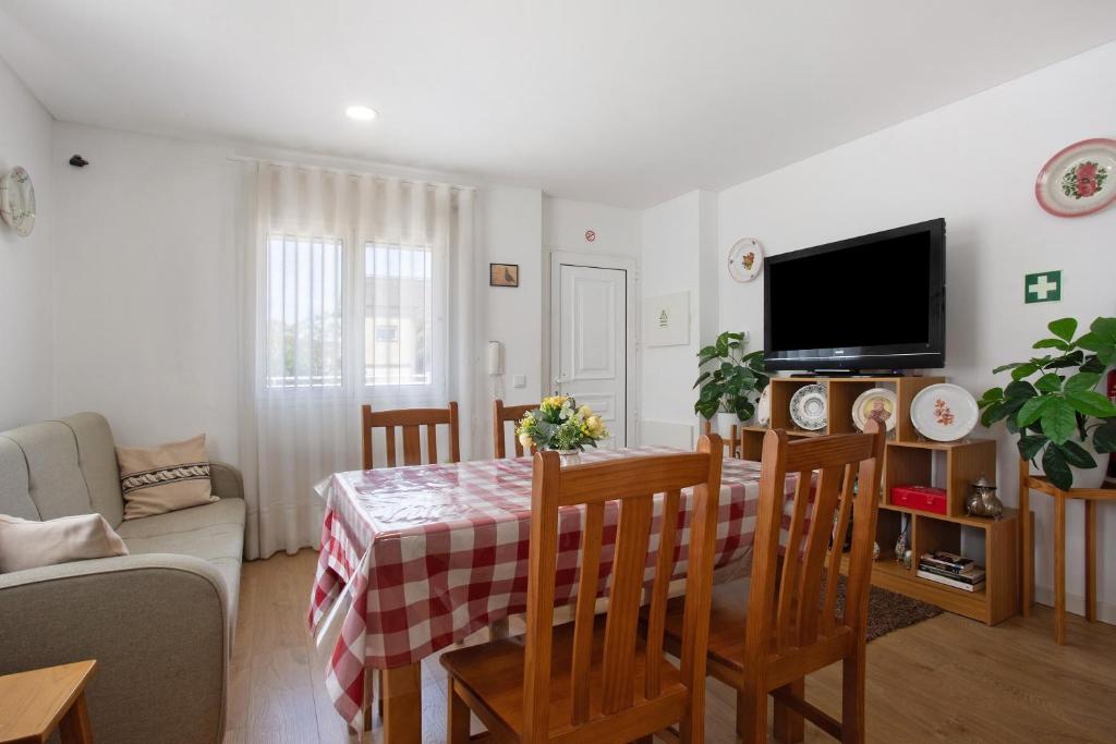 a living room with a table and a tv at Monte Dos Pastorinhos in Fátima