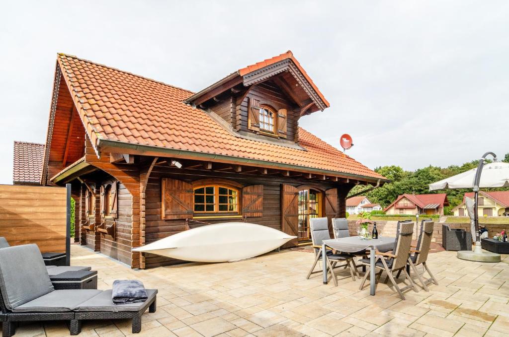 a house with a large boat on a patio at Das Alpenhaus an der Ems in Walchum