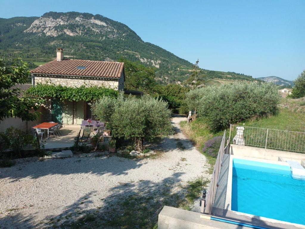 a house with a swimming pool in front of a mountain at Le Vieil Olivier in Sahune