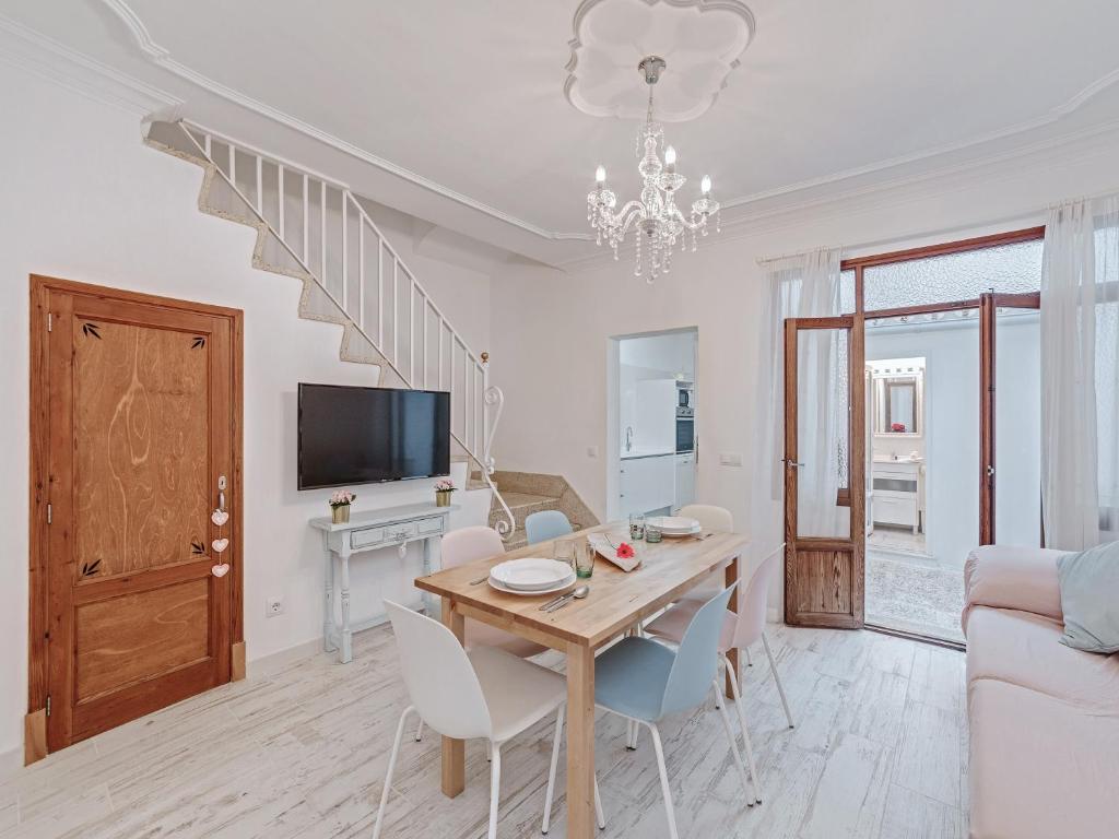 a living room with a dining room table and a tv at Casa Convent in Alcudia