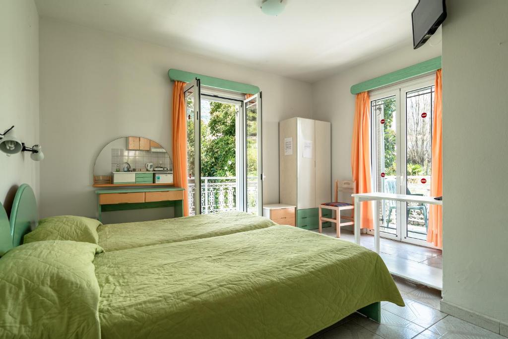 a bedroom with a green bed and a refrigerator at Angela partial sea view 6 in Kefallonia
