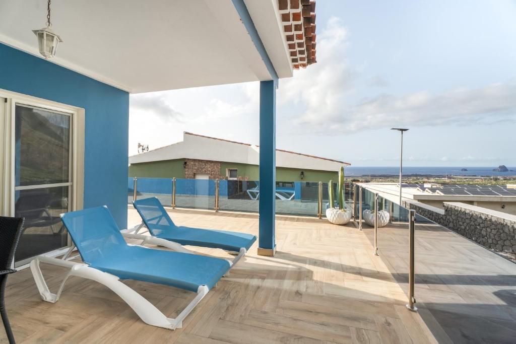 two blue chairs sitting on the deck of a house at Casa Mar Azul in Frontera
