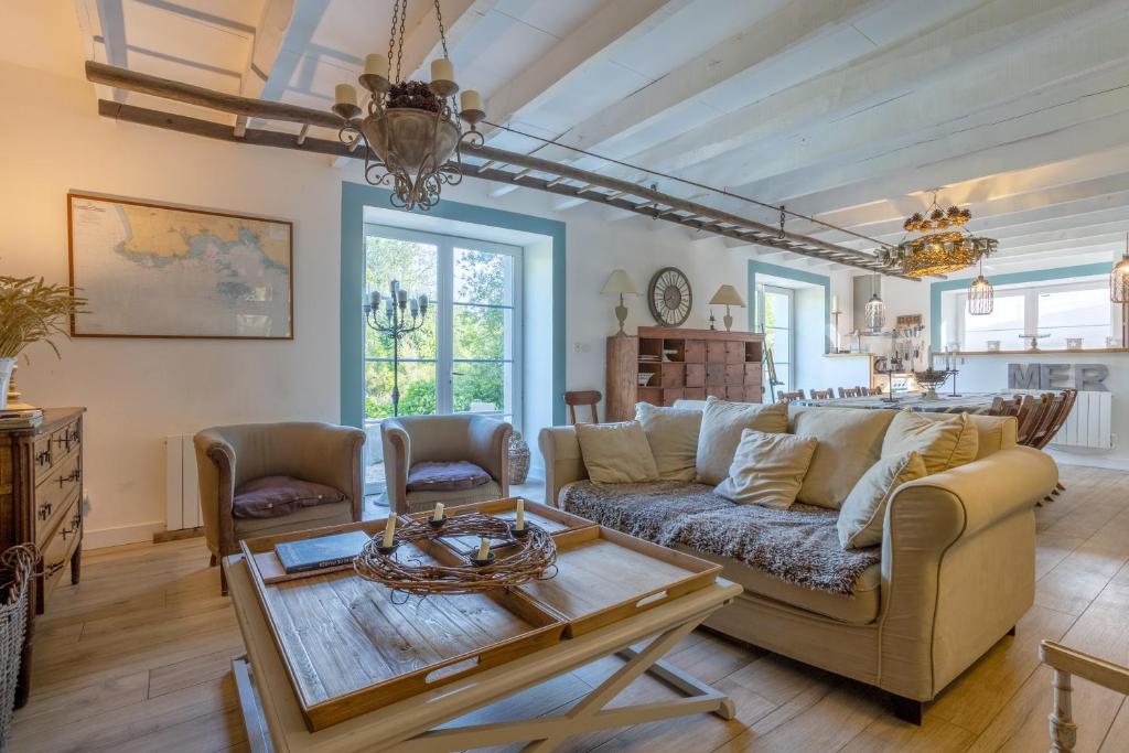 a living room with a couch and a table at La bonne descente in Fouesnant