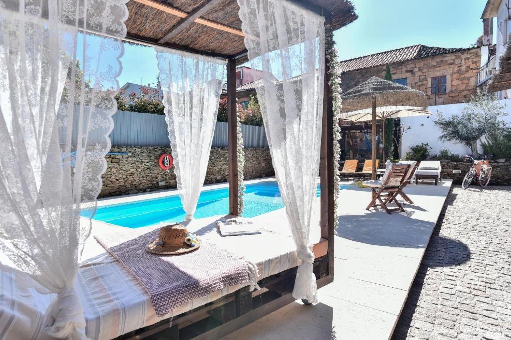 a bedroom with a canopy bed next to a swimming pool at Casa Douro Janja in Armamar