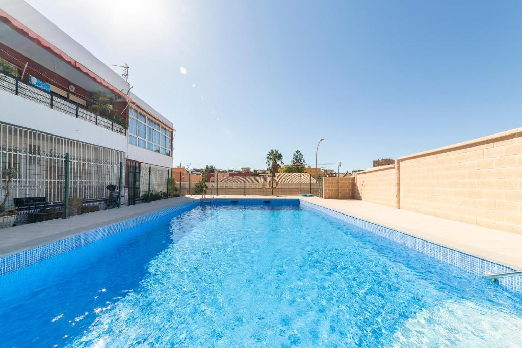 a large blue swimming pool next to a building at Gaviotas 4 in Aguadulce