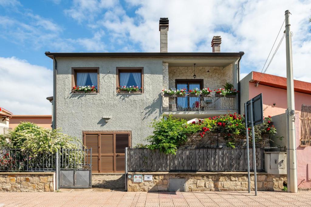 a house with flower boxes on the windows at Gerani Rossi Appartamento in Villa San Pietro