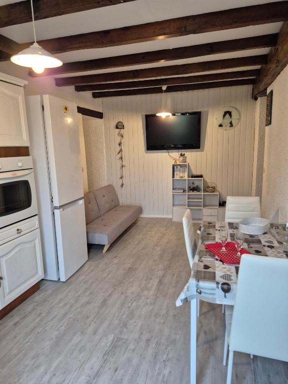 a kitchen and living room with a table and a couch at Mamie Krema in Boresse-et-Martron