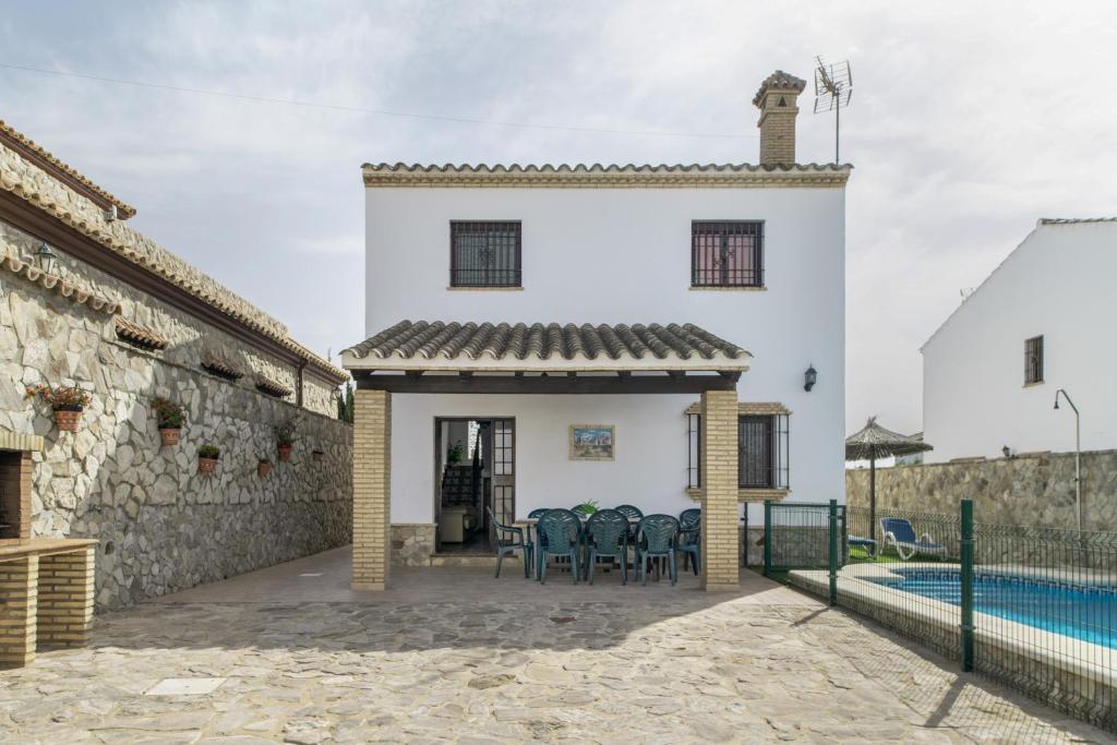 a white house with a patio and a swimming pool at Casa Carmelo 2 familias o parejas in Conil de la Frontera
