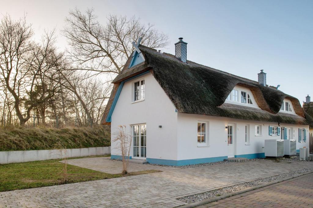 a white house with a black roof at Ferienhaus Mühlenperle in Güstow