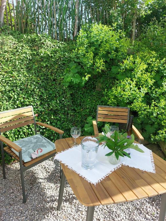 a wooden table with two chairs and a table with glasses at Krottenhill 2 ¼ in Ingenried
