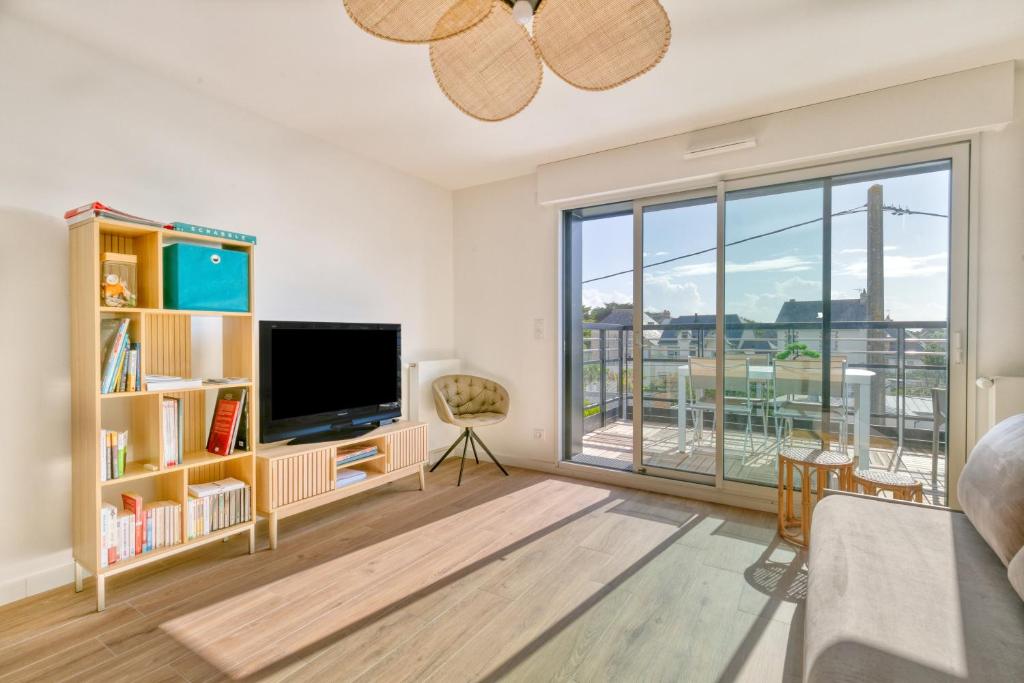 a living room with a tv and a large window at Appartement Port Lin proche Océan in Le Croisic