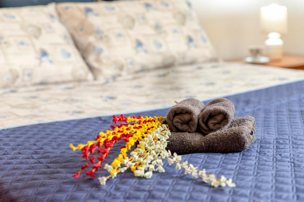 a pair of towels and flowers on a bed at Appartamento Libio Porto Torres in Porto Torres