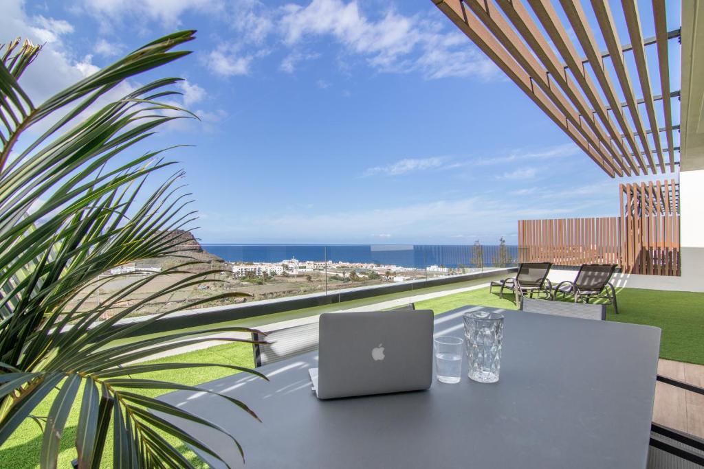 a laptop computer sitting on a table on a balcony at Suitme-Agaete in Agaete