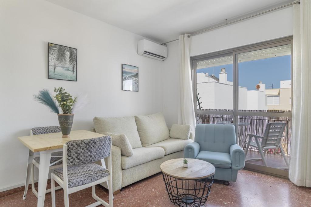 a living room with a couch and a table and chairs at Apartamento Playa Regla in Chipiona