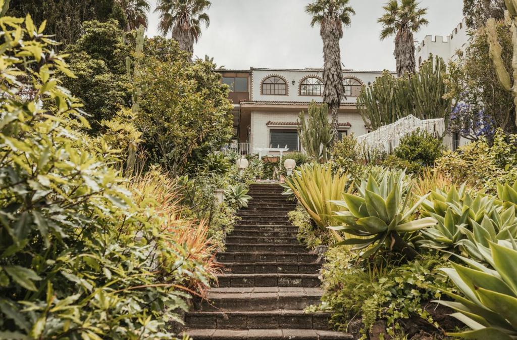a set of stairs in front of a house with palm trees at Bastion del Drago in Arucas