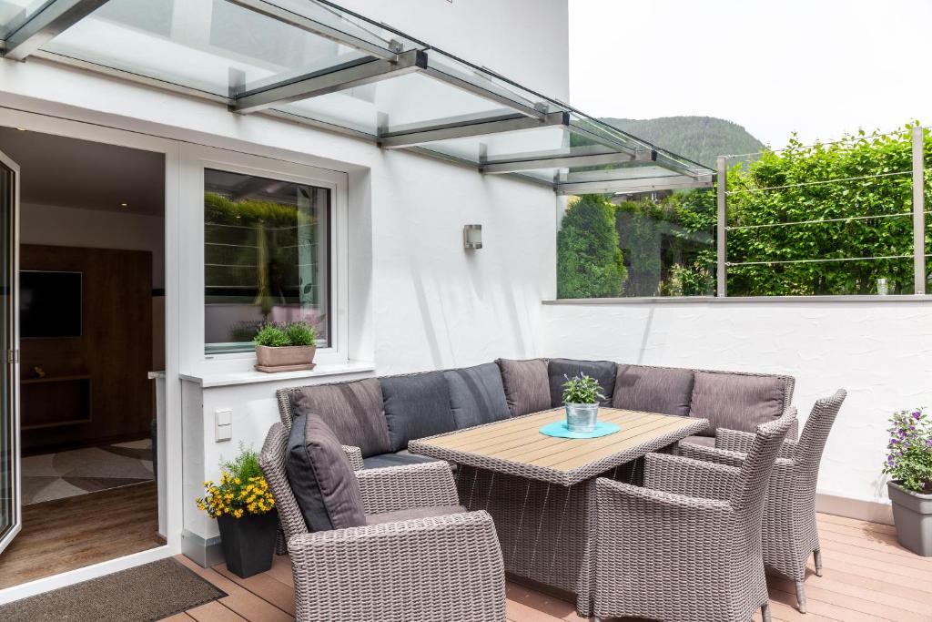 a patio with a table and chairs and a couch at Haus Alpenheim Apartment 2 in Tux