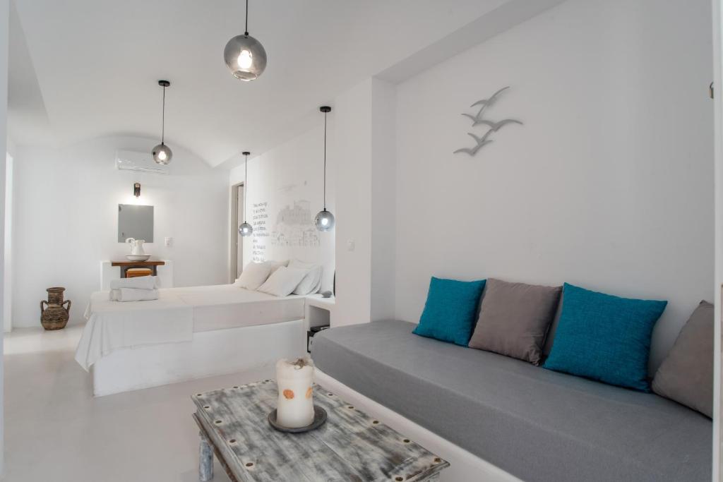 a white living room with a couch and a table at Helmos Cozy Studio in Naxos Chora