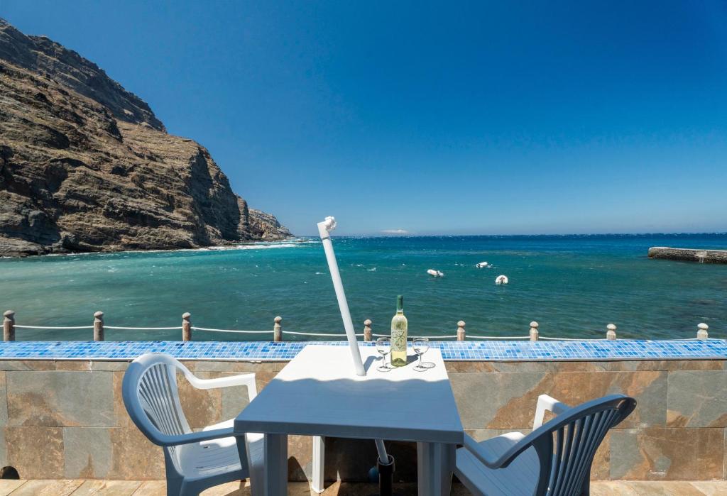 a table and chairs with a view of the ocean at Apartamentos Playa Azul - 2 in Vallehermoso