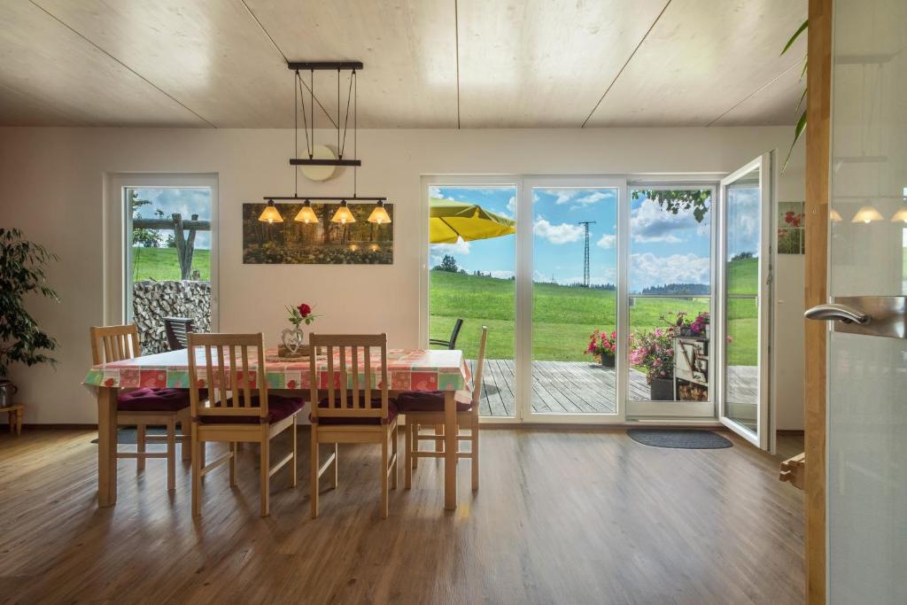 a dining room with a table and chairs and windows at Ferienhof Weber Ferienwohnung Buche in Neukirch