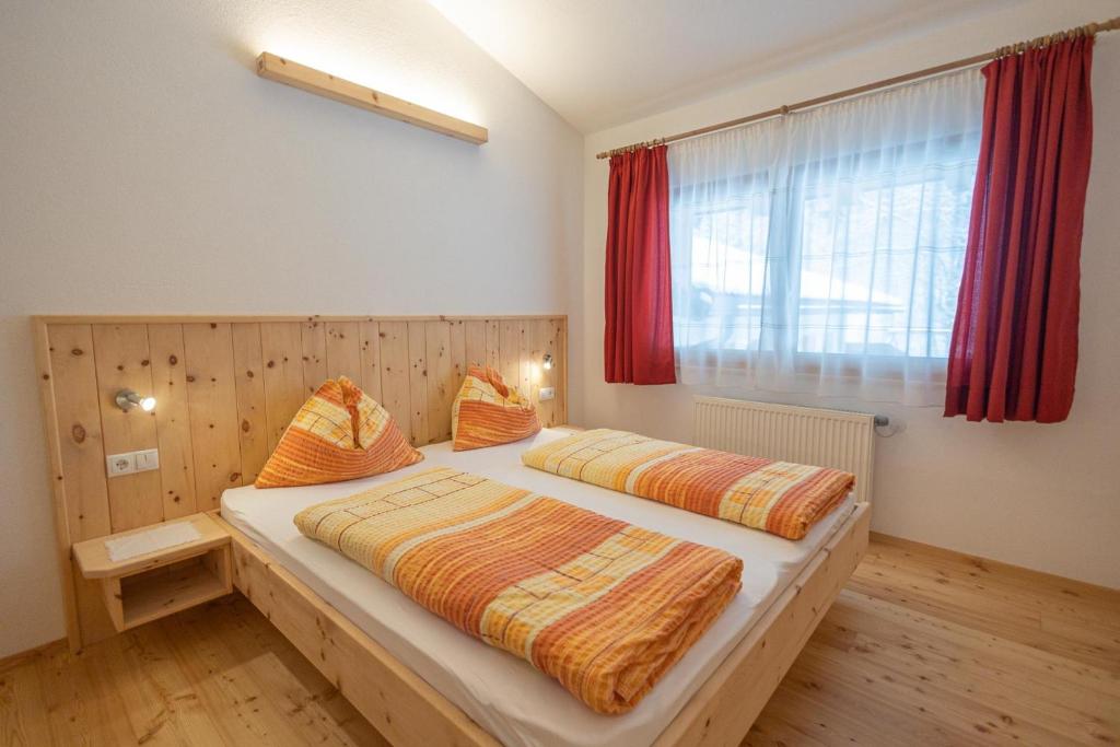 a bedroom with two beds and a window at Apartment Enzian - Mesnerhof in Sand in Taufers
