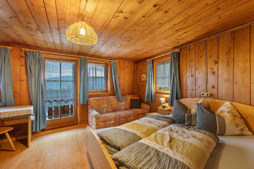 a bedroom with a bed and a couch at Oberhof Bauernhaus in Vallarga