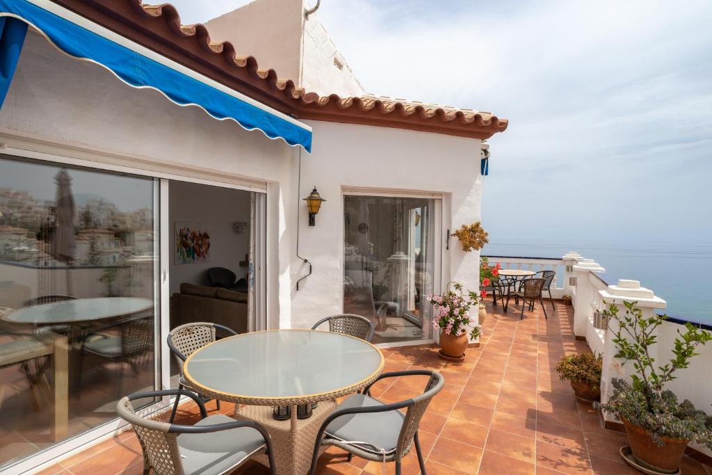 a balcony with a table and chairs and the ocean at Casa Sydhavshytten in Nerja
