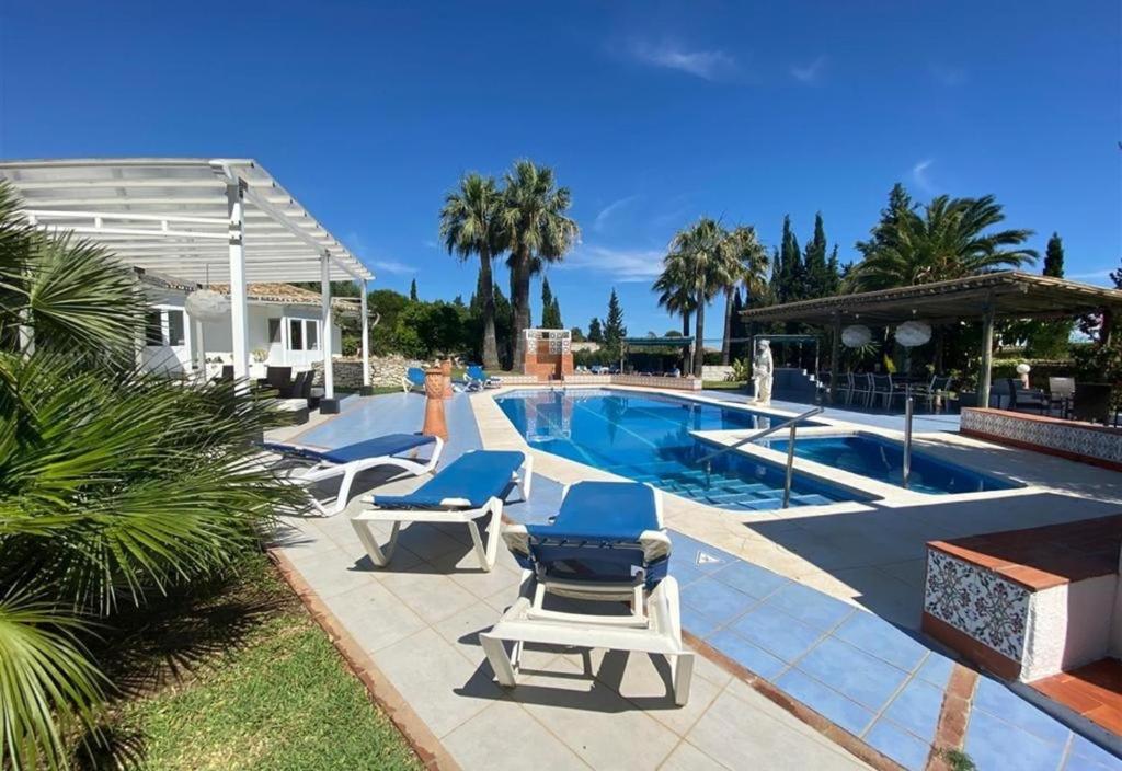 a swimming pool with two lounge chairs next to a swimming pool at Casa Harriet in Mijas