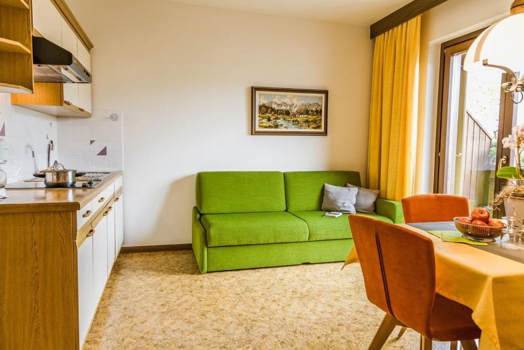 a green couch in a kitchen with a table at Ferienwohnung Lanz 2 in Lana