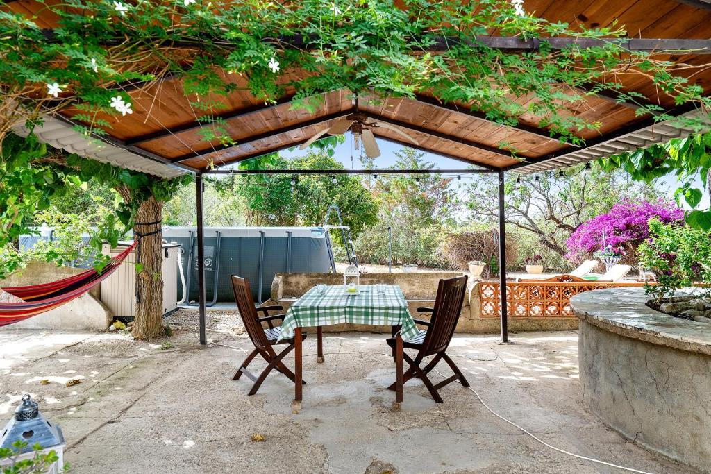 a patio with a table and chairs under a pergola at Can Wancho in Botarell