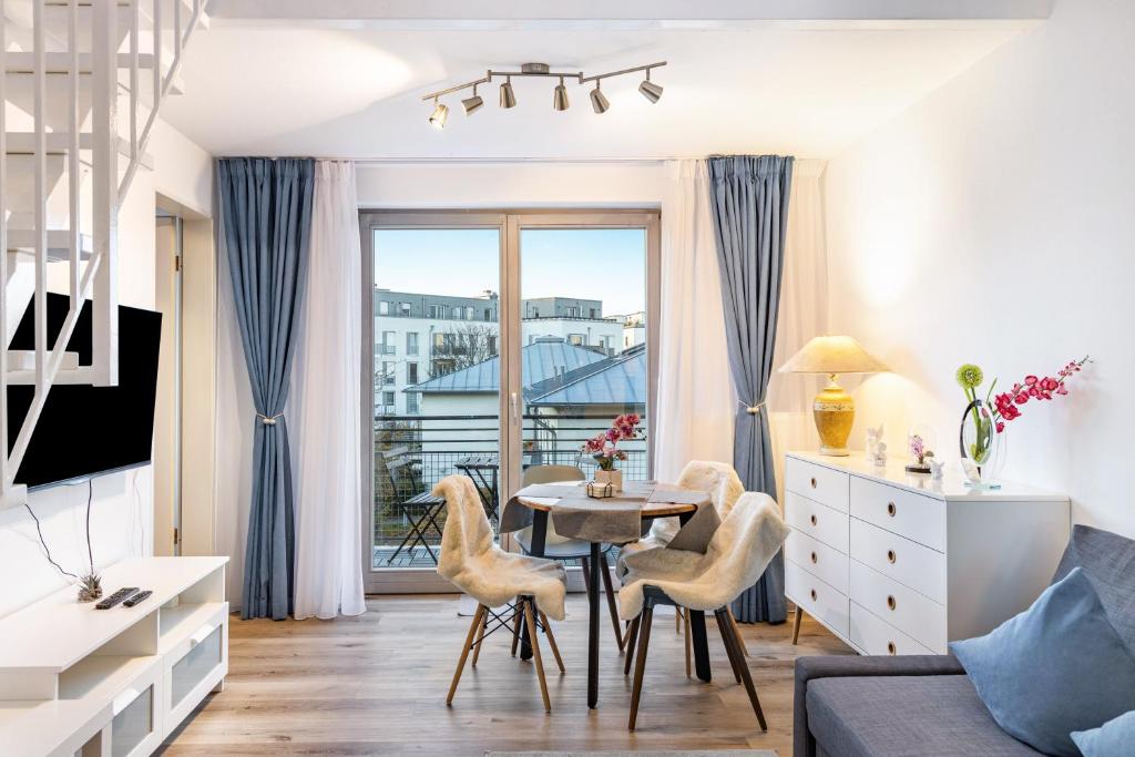 a living room with a table and chairs and a window at Nahe Airport Ber Maisonettewohnung in Schönefeld