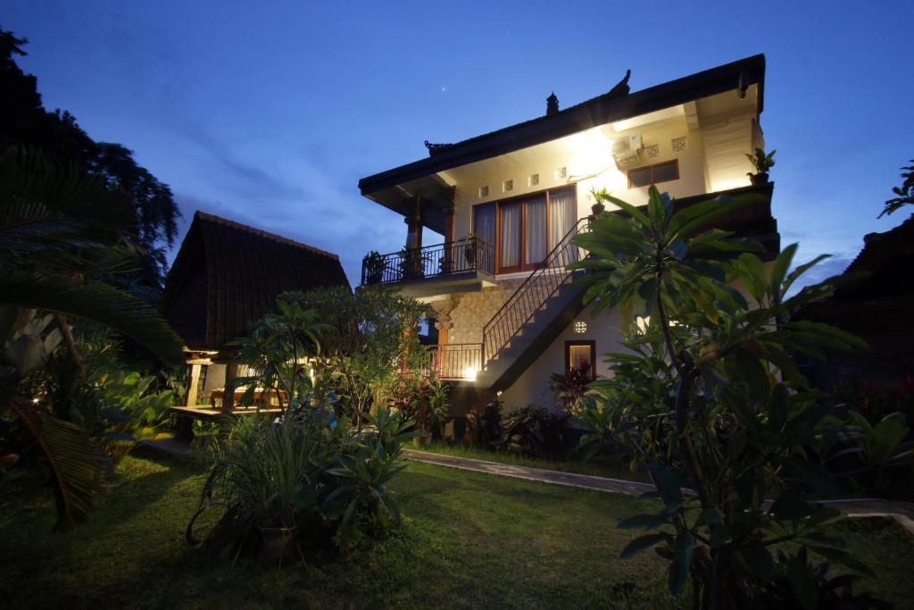 ein Haus mit nachts eingeschaltetem Licht in der Unterkunft Loris Homestay in Ubud
