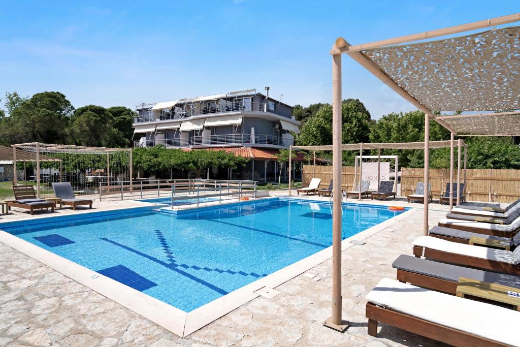 a large swimming pool with a house in the background at Iguana studio 10 in Preveza