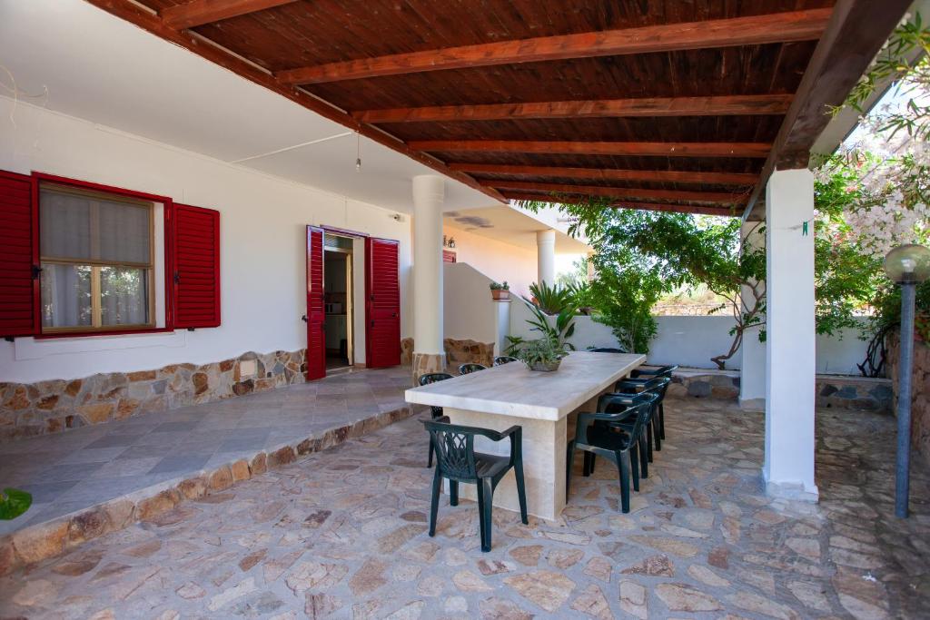 a patio with a wooden table and chairs at Casa delle Mimose in Orosei