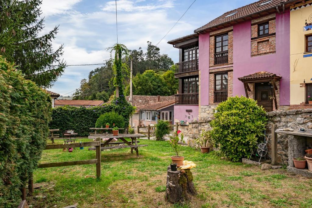 a pink house with a picnic table in front of it at Casa Florenta G2 in Cangas de Onís